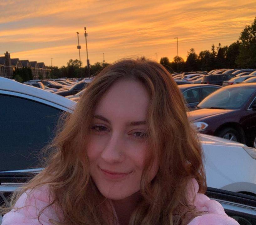 Girl taking selfy in front of sunset/sunrise